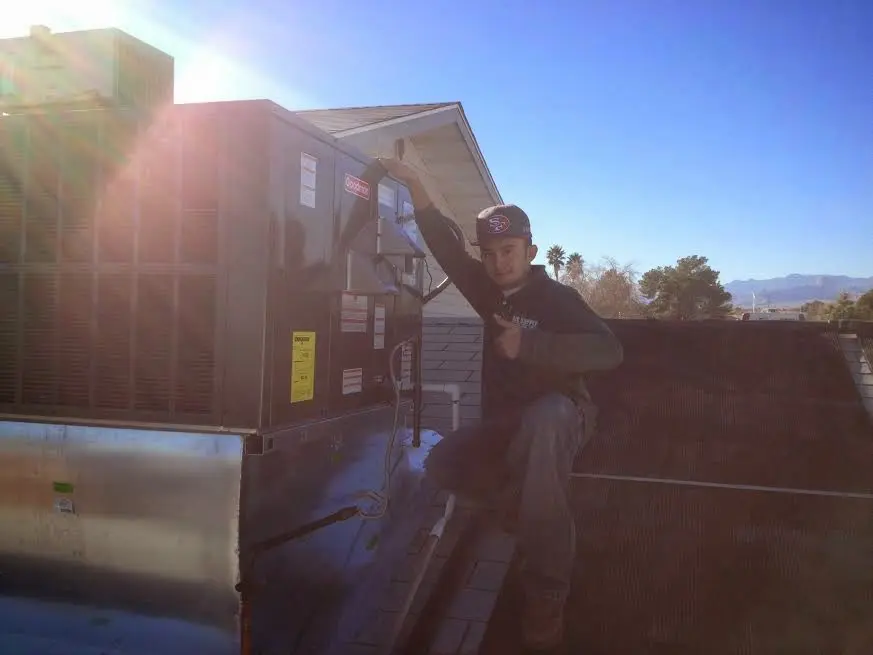 HVAC technician performing Heat Pump Repair on a rooftop unit in Magalia